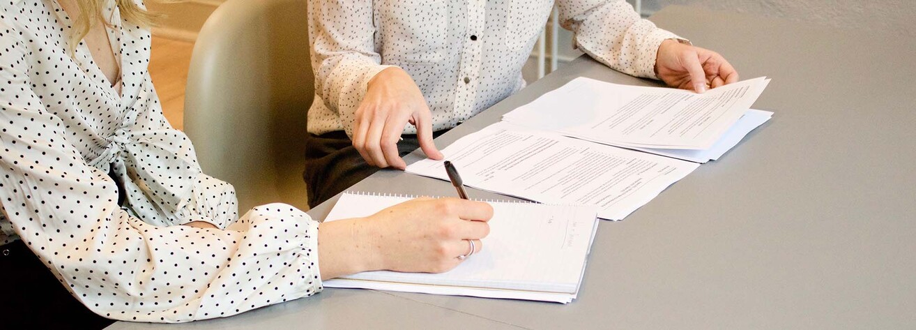 Bild på papper och händer som håller i dem.